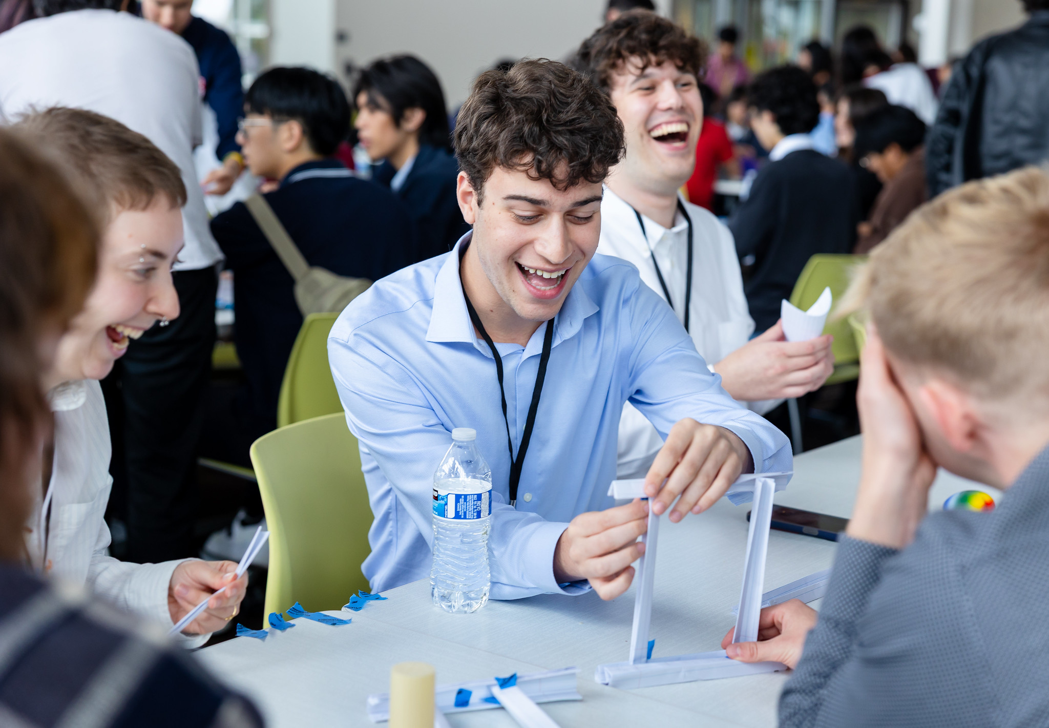 Attendees building a paper bridge.